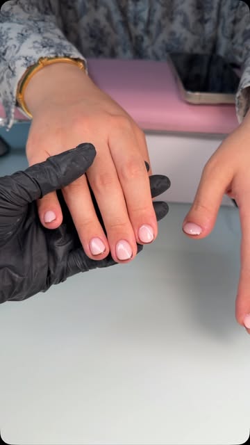 Short rounded nails with a clean, translucent pink finish by Karina